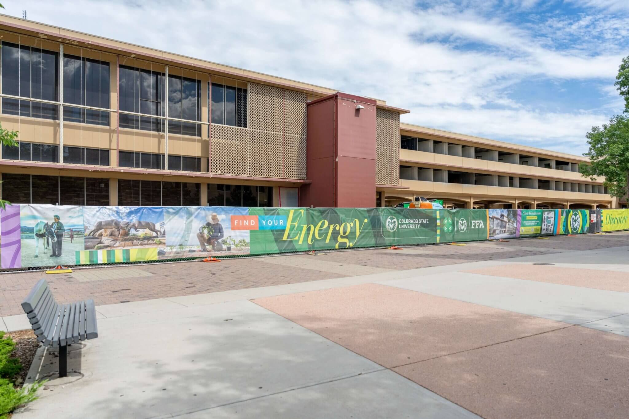 Photo of CSU's Clark Building under construction with a branded fence wrap, with photos, CSU, 4-H, and FFA logos, and the words "Find Your Energy"